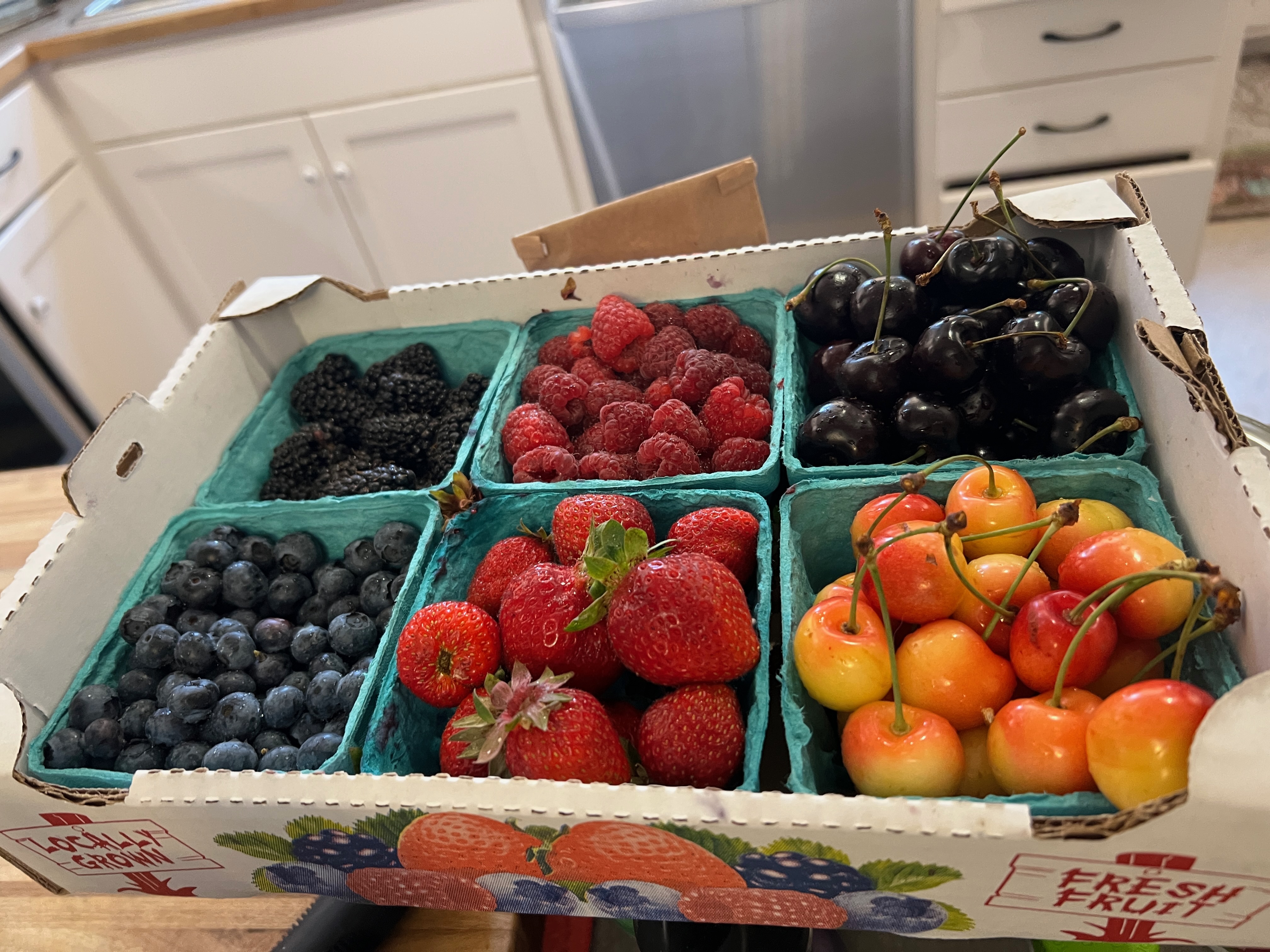 A flat of different kinds of berries.