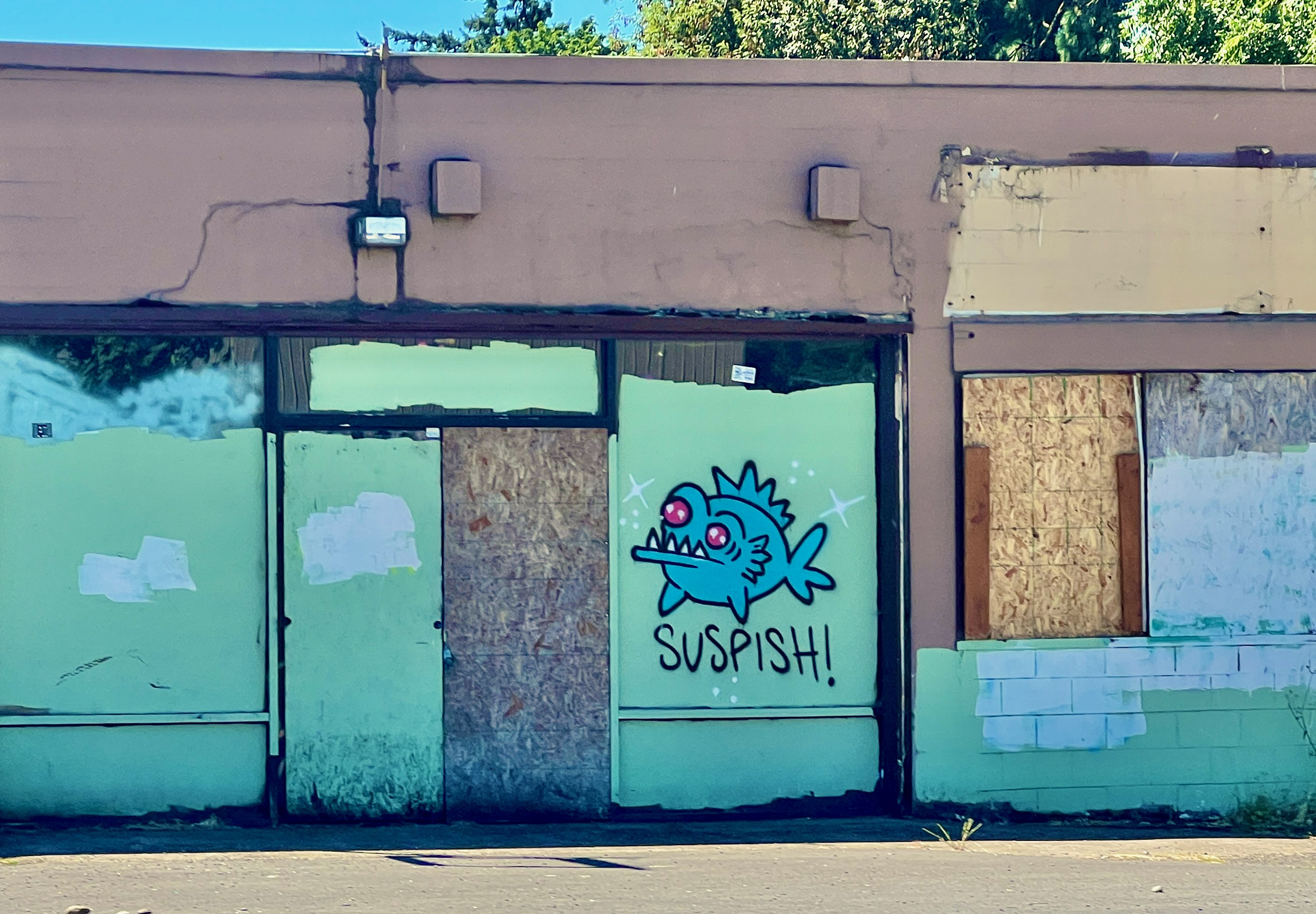 Graffiti of a fish that says 'suspish' under it.