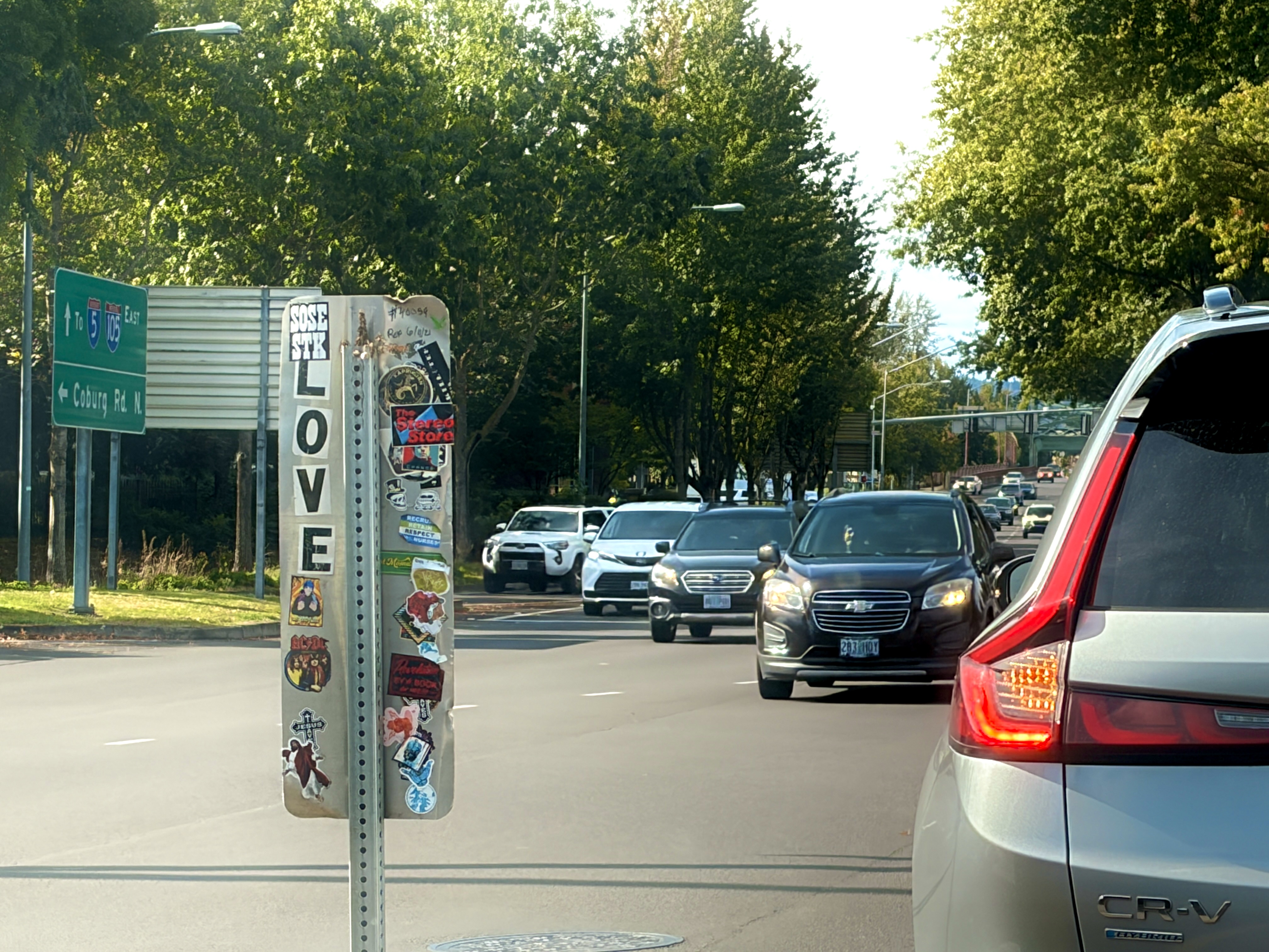 A street sign covered in stickers, and five block letter stickers that spell out LOVE.
